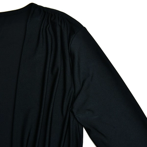 Vue détaillée de la robe noire à col en V montrant les plis aux épaules et la texture