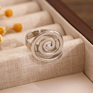 Macro shot of silver spiral metal ring with adjustable opening in a wooden jewelry box