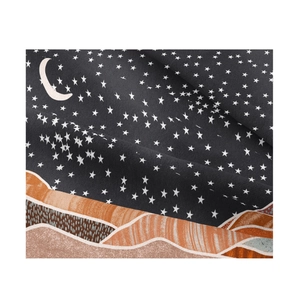 Detail shot of moon and stars pattern on soft textile fabric with abstract hills design