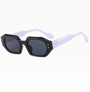 Detail view of hexagonal sunglasses with black frame, white temples, and silver rivets