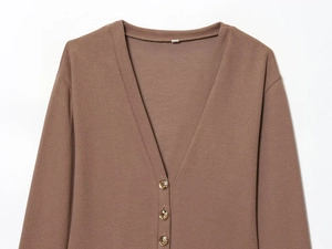 Detailed view of brown knit cardigan featuring V-neck and embossed gold buttons