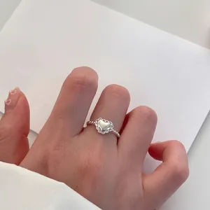Primer plano de anillo de corazón de plata s925 con textura de cuentas en dedo