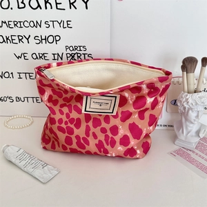 Dettaglio del beauty case leopardato rosa con cerniera ed etichetta logo in tela