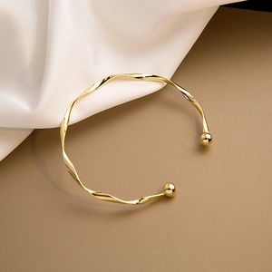 Bracciale rigido Mobius dorato con terminali a sfera su seta e pelle di tendenza