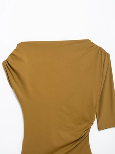 Detailed macro view of ginger yellow knit fabric showing ribbed texture and side ruching
