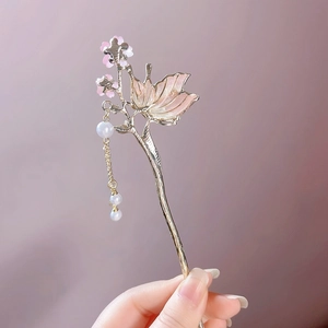 Vue détaillée de l'épingle à cheveux dorée avec pétales roses et glands en perles