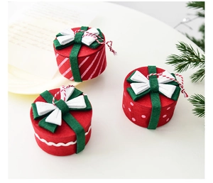 Detailed view of mini felt Christmas gift box ornaments with hanging strings in red and green