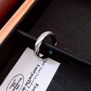 Detailed view of silver twisted ring with paved zircon stones on a black velvet display