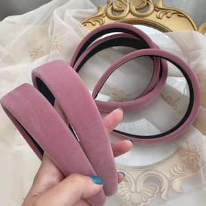 Gros plan du serre-tête en velours rose avec texture douce et design rétro épais