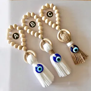 Three assorted wooden bead evil eye pendants with long cotton tassels for wall or car decor