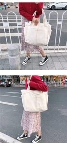 Détail d'un grand sac fourre-tout en toile crème avec plusieurs poches de rangement