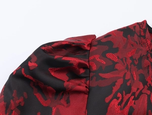 Gros plan détaillé du tissu jacquard floral rouge et noir sur l'épaule de la robe