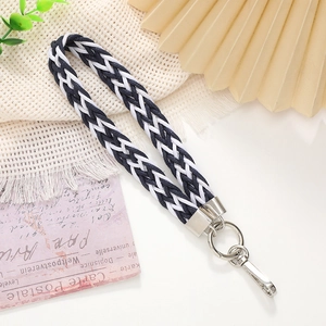 Close-up of black and white woven phone wrist strap with silver metal spring clasp