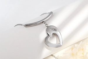 Close-up of a silver heart-shaped pendant necklace with three inlaid rhinestones