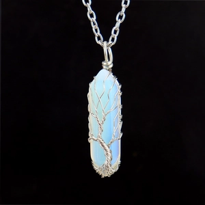Macro detail of Tree of Life pendant with silver wire wrapped around white opal stone
