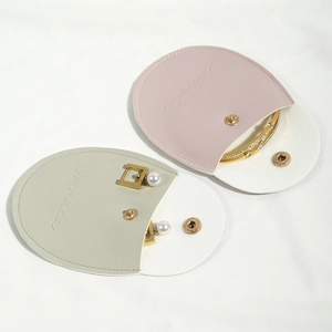 Detail view of pink and grey PU leather jewelry pouches with snap buttons and gold jewelry