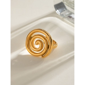 Close-up of polished 18k gold plated stainless steel spiral ring on ceramic surface