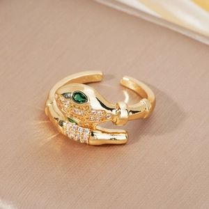 Detailed view of snake ring with green stone eyes and pave rhinestones in gold
