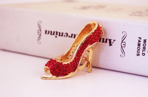 Macro shot of gold alloy high heel keychain featuring dense red rhinestone embellishments