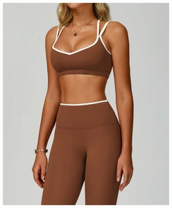 Detail of cross-back sports bra with white trim and high-waisted yoga leggings