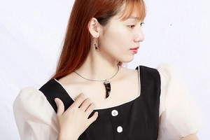 Détail du collier et des boucles d'oreilles léopard portés par un mannequin