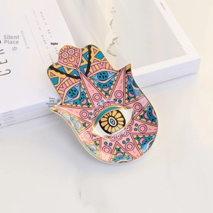Detailed view of the Hamsa Hand ceramic jewelry tray with colorful evil eye patterns