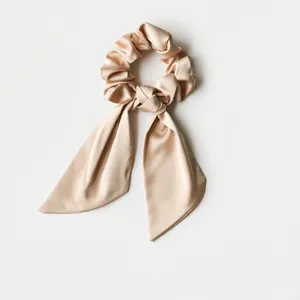 Elegant champagne gold satin scrunchie with long ribbon bow in premium silk texture