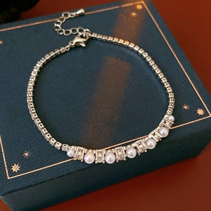 Detailed close-up of zircon and pearl bracelet with lobster clasp on luxury jewelry box