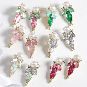 Flat lay of geometric pear-shaped drop earrings with micro-set pearls and colorful crystals