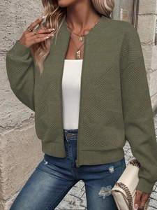 Detail of army green bomber jacket featuring geometric diamond quilted fabric texture