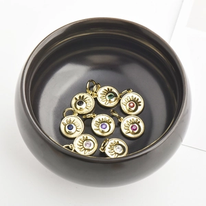 Macro view of colorful zircon evil eye charms with golden plating in a black bowl