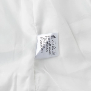 Detail of fabric washing label on white textile vest set with care instructions