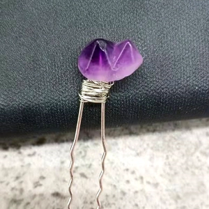 Macro detail of natural amethyst quartz hair pin with silver wire wrapping technique