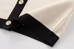 Macro shot of knit fabric texture with contrasting hem and gold embossed buttons