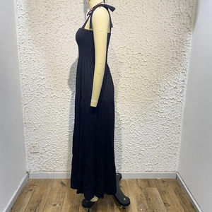 Detail of multi-layered tiered skirt hem on a black sleeveless summer maxi dress