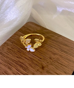 Detail of three butterflies open ring featuring gold plating and cubic zirconia inlay