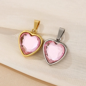 Detailaufnahme von herzförmigen rosa Kristallanhängern mit Gold- und Silberstahlrahmen