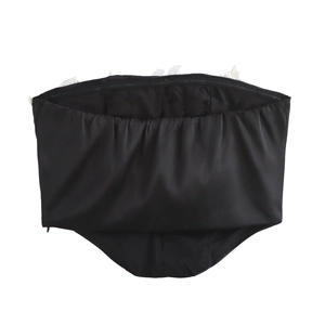 Detailaufnahme eines schwarzen Schlauch-Tops mit zarter weißer Spitze und schlichter Textur