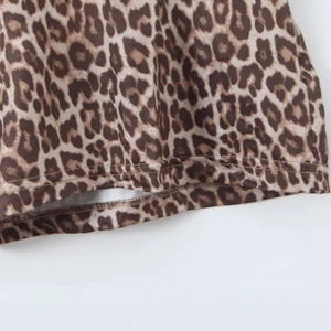 Close-up of leopard print bodysuit hem showing high-quality double stitching and fabric