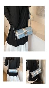 Detail view of light blue denim cylinder bag with silver metallic chain and buckle