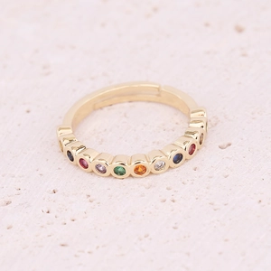 Macro detail of adjustable gold ring featuring vibrant multi-colored zirconia stones