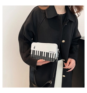 Detailed view of musical note crossbody bag with piano keyboard print and music logo