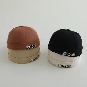 Close-up of four colored canvas docker caps for babies with cute animal embroidery