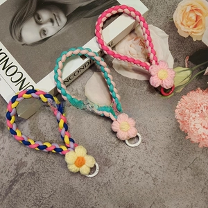 Macro shot of colorful braided flower wrist straps with round metal clips for phone cases