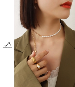 Detail of freshwater pearl necklace and gold stainless steel ring set on model