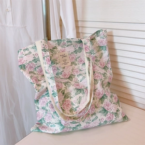 Close-up of pink rose floral canvas tote bag featuring a vintage rectangular fabric label