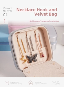 Travel jewelry box detail showing three necklace hooks and a storage pocket in velvet lining