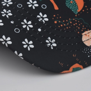 Detailed close-up of a tie-dye baseball cap brim with floral patterns and sturdy stitching