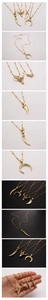 Detailed macro view of gold-plated bull head and crescent moon charms on satellite chains