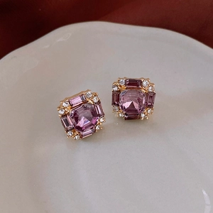 Macro detail of vintage square purple crystal earrings with gold plating on ceramic